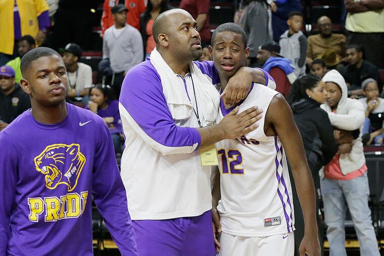 A Camden coach comforts Deaquan Williams after losing.