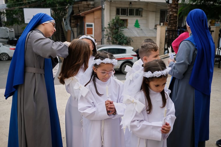 Children and nuns gather outside the Holy Family Catholic Church before attending Mass on Sunday ahead of Christmas celebrations in Gaza City.