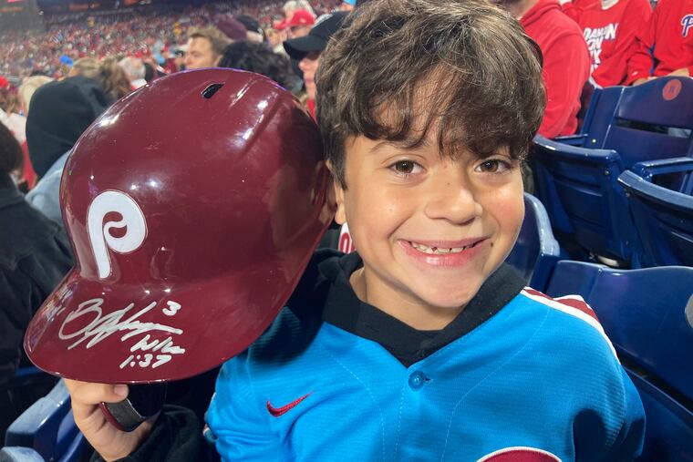Hayden Dorfman, 10, of Voorhees, N.J., holds up Philadelphia Phillies slugger Bryce Harper’s autographed helmet during a baseball game against the Pittsburgh Pirates, Thursday. Harper tossed his helmet into the stands after he was ejected and it was retrieved by Dorfman.