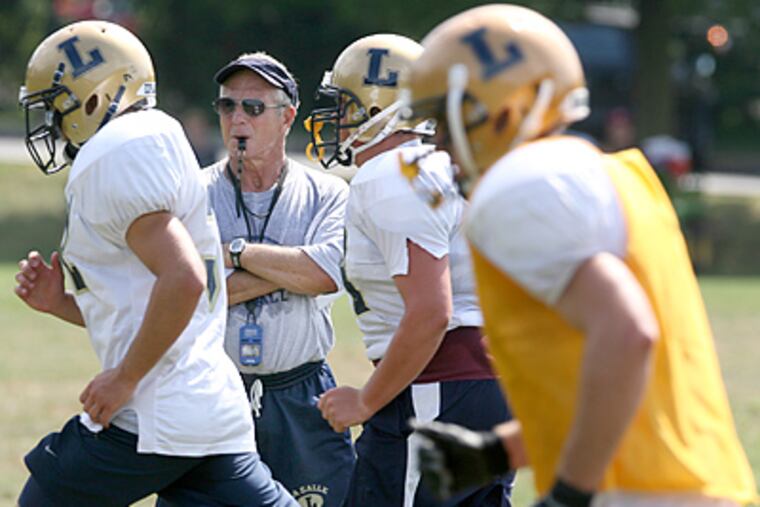 La Salle High School head coach Drew Gordon, center, watches his team run sprints. (Charles Fox / Staff Photographer)