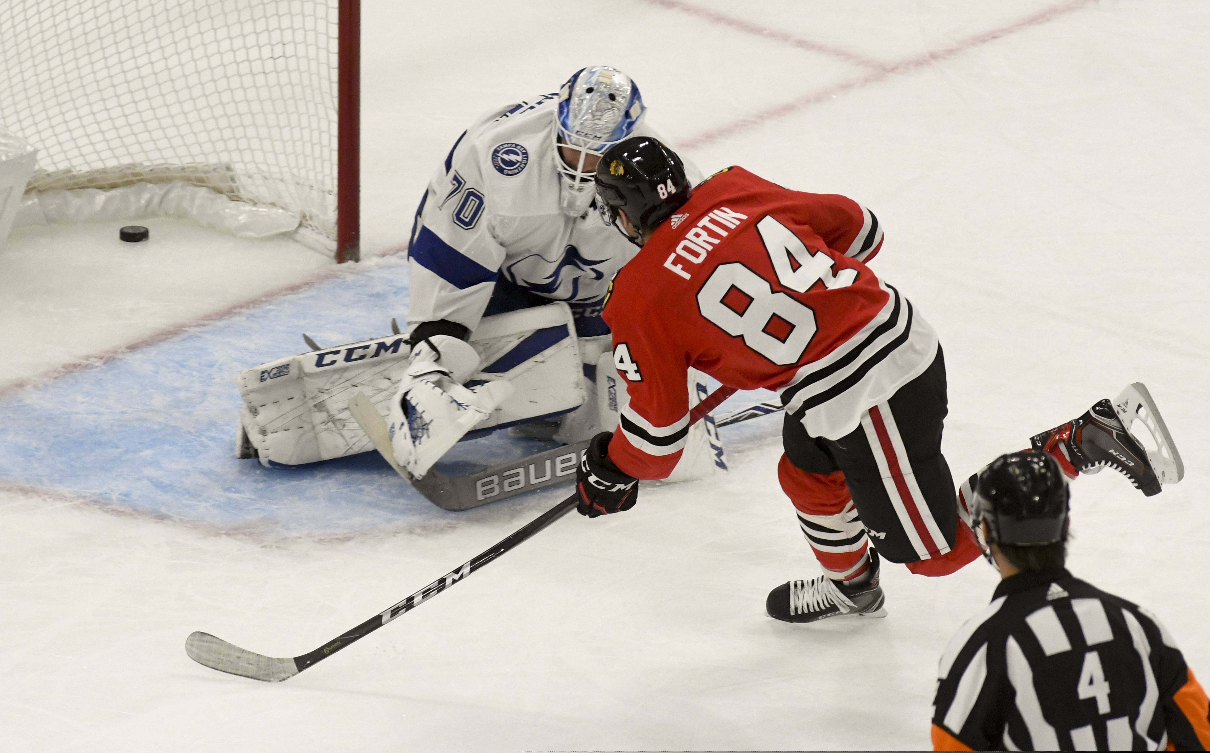 Chicago Blackhawks left wing Alexandre Fortin (84) scores a goal past Tampa Bay Lightning goaltender Louis Domingue (70) during the first period of an NHL hockey game on Sunday Oct. 21, 2018, in Chicago. (AP Photo/Matt Marton)