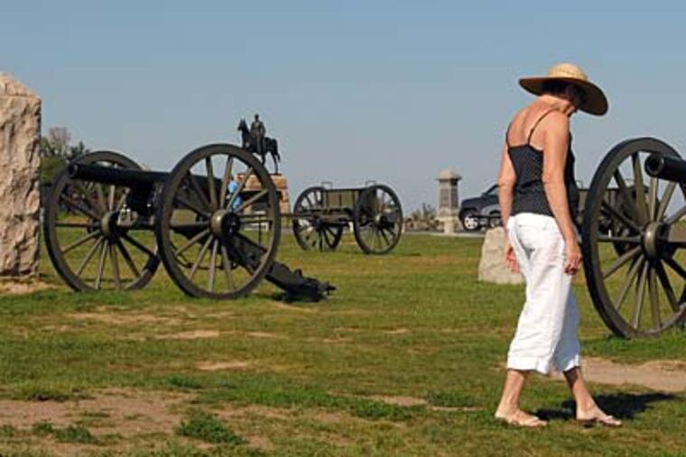 A tourist walks on the hallowed ground of the Gettysburg battlefield amid the three-inch guns of the Army of the Potomac, led by Maj. Gen. George G. Meade in 1863. (TOM GRALISH / Staff Photographer)