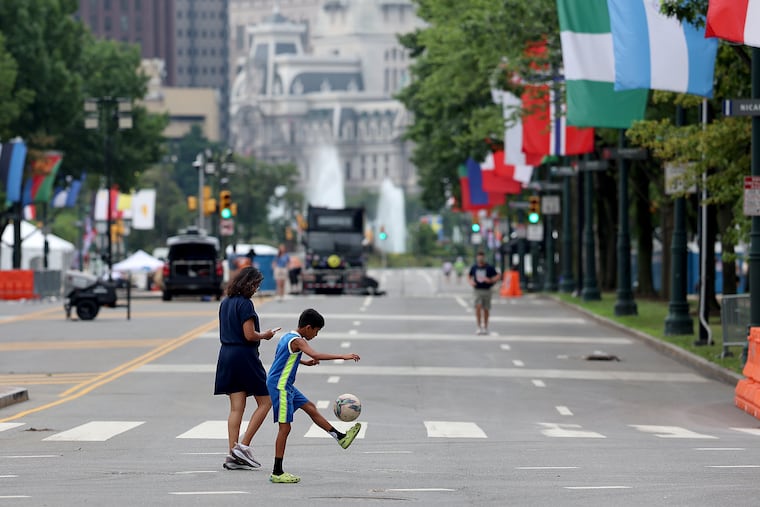 Adiv Premsun, 9, of Newtown, Pa. kicks a soccer ball along the Ben Franklin Parkway as the cleanup continues in Philadelphia on Sunday, July 5, 2026.