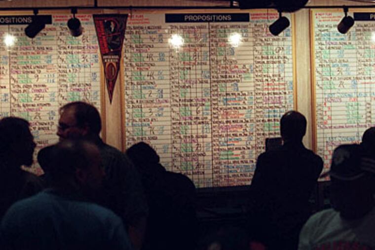 The Super Bowl may be in Miami, but for many the real action is in Las Vegas, where point spreads are set and XLIV-karat fortunes are won and lost. Above, raking in heavy action at the Mirage. (LENNOX MCLENDON / Associated Press)