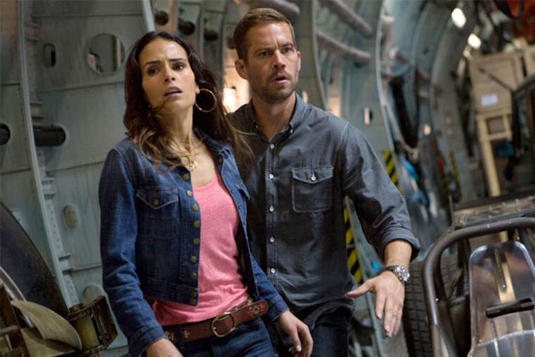 This film publicity image released by Universal Pictures shows Jordana Brewster, left, and Paul Walker in a scene from "Fast & Furious 6." (AP Photo/Universal Pictures, Giles Keyte)