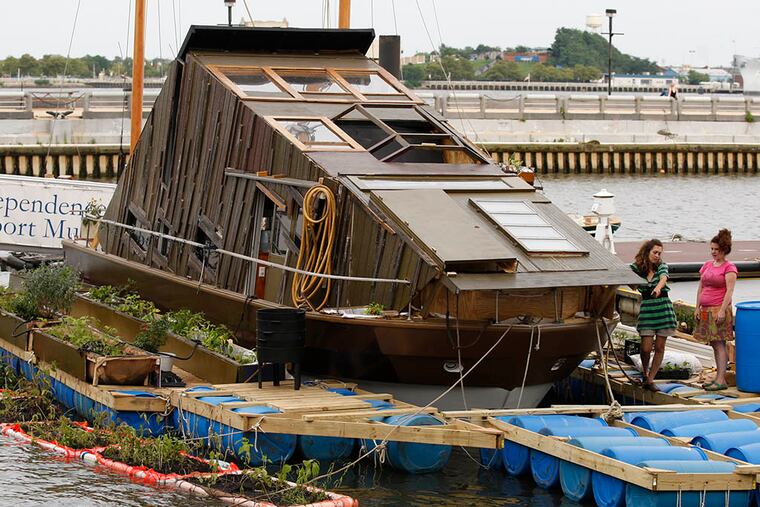 Mary Mattingly, left, and Karla Stingerstein work on the ecosystem. Brooklyn artist Mary Mattingly is living on a floating self-contained ecosystem that appears as a semi-submerged row house on the river by the Independence Seaport Museum. (RON CORTES / Staff Photographer )