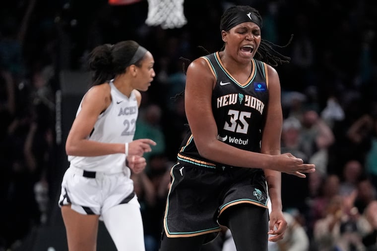 New York's Jonquel Jones (right) celebrates in front of Las Vegas' A'ja Wilson after making a big three-pointer during the fourth quarter.