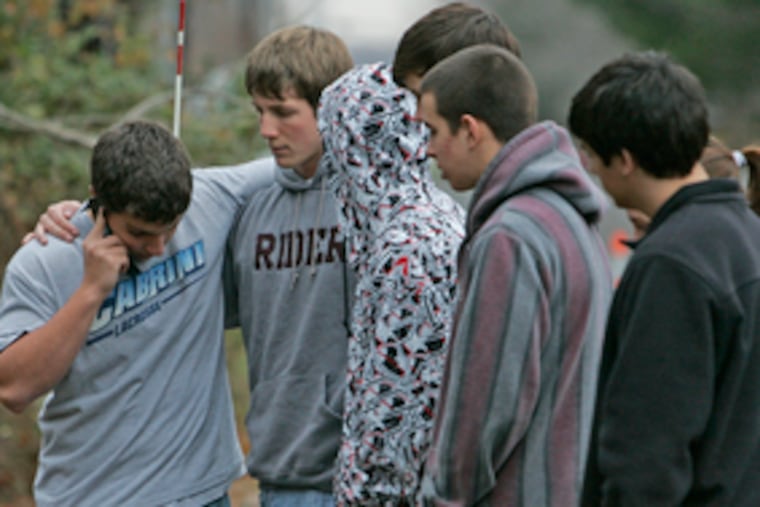 Moorestown High students comfort one another at the crash site. Grief counselors were on hand for faculty and students.