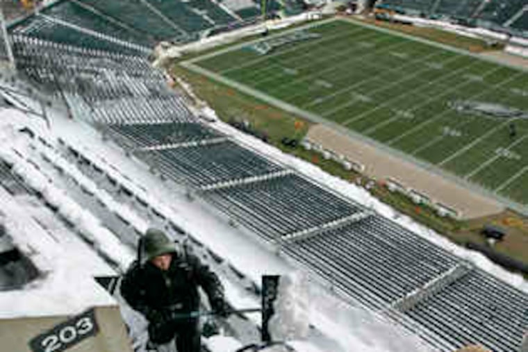 Chris Leigh shovels snow into a large blue barrel to be dumped in the Linc's upper concourse.