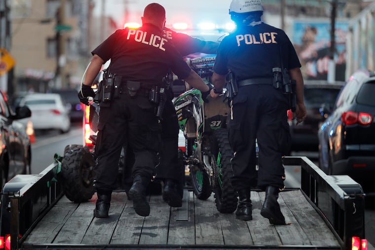 Phila. police roll a confiscated dirt bike onto a trailer on 5th St. near Allegheny after the driver had been operating it on the streets in Phila., Pa. on Sept. 26, 2020. Police on scene said they have had a special bike detail for the last 2 days. Police working in the air spot motorcycles/ ATV's that are stopped then specially trained police on dirt bikes move in and confiscate the motorcycles. If the drivers check out they are issued summons and will have to pay big fines to get their bike back. If drivers have outstanding warrants they are taken into custody.