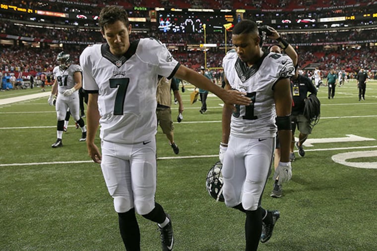 Eagles' Sam Bradford, left, gives Jordan Matthews, right, a pat as they walk off the field after the game. The Eagles lose 26-24 to the Atlanta Falcons at the Georgia Dome in Atlanta.
