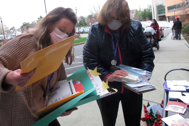 Kathleen Schallus (left) and Suzanne Marino bring holiday cards to Shore Medical Center in Somers Point, N.J., during the pandemic in 2020. The once-beloved tradition of sending cards is slowly dying, writes Elizabeth Luciano.