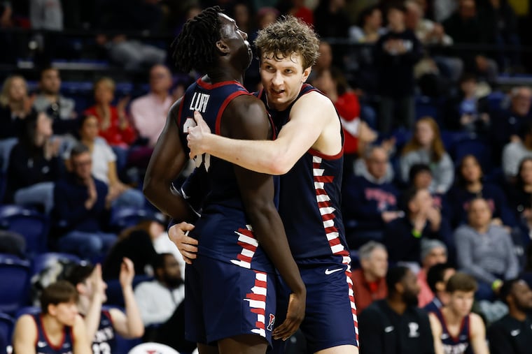 Penn forward TJ Power (right) and teammate forward Lucas Lueth celebrate their win over Cornell on Saturday.