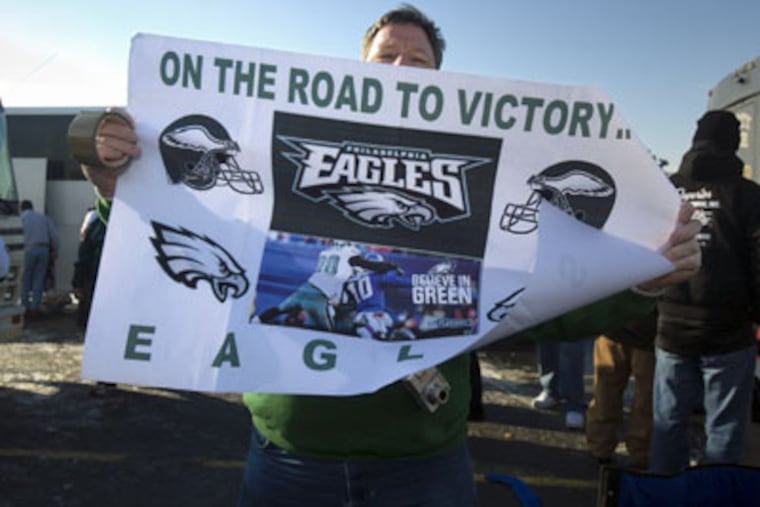 John Graber, of Levittown, Pa., holds up a road to victory Eagles sign while tailgating at the Meadowlands before last Sunday's Eagles-Giants game. (Ed Hille / Staff Photographer)