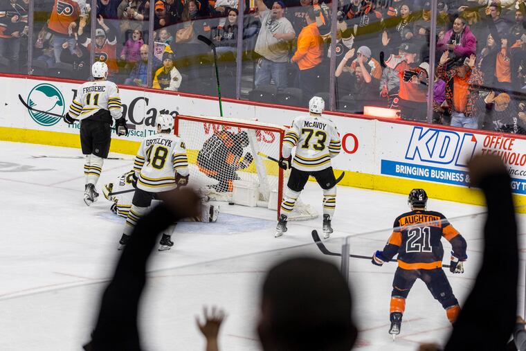 The Flyers Travis' Konecny, (behind the net) scores against the Boston Bruins at the Wells Fargo Center on Saturday.
