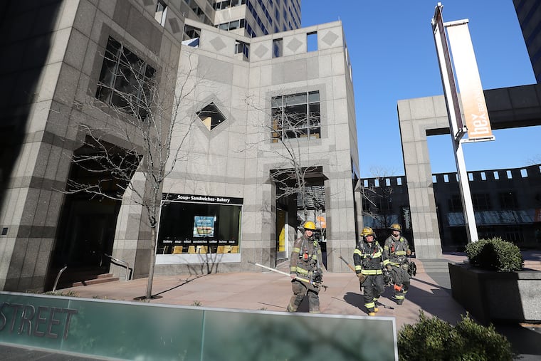 Philadelphia firefighters leave Commerce Square on the 2000 block of Market Street in Philadelphia on Sunday after a brief fire on the top floor.