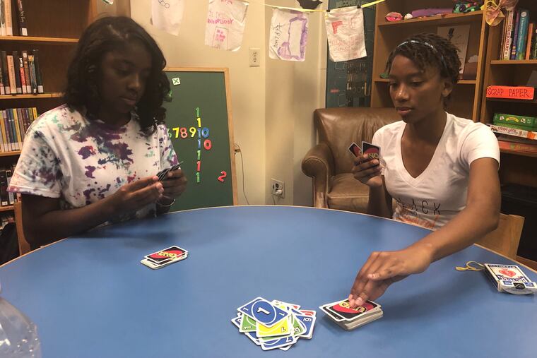 Nydirah Torrence, 17, left, and Simone Lockwood, 17, play Uno in the children's area of the Philadelphia City Institute library on July 15, 2019.
