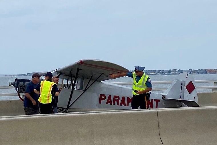 Police examine a banner plane that made an emergency landing on the bridge between Somers Point and Ocean City on Monday, July 19, 2021.