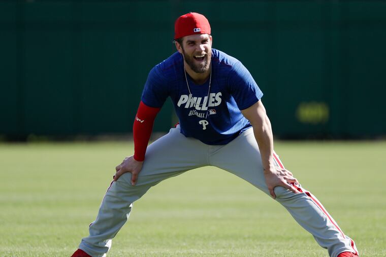 Bryce Harper has a laugh while stretching at Phillies practice on Sunday.