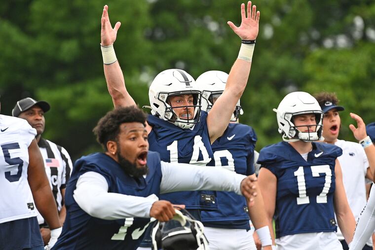 Penn State quarterback Sean Clifford (14) and linebacker Ellis Brooks (13) react to a play during practice on Aug. 7.