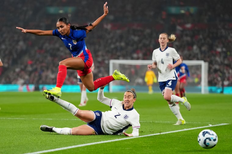 U.S. forward Alyssa Thompson jumps over England's Lucy Bronze during Saturday's game.