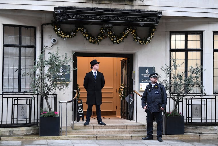 Police and hospital personnel outside King Edward VII's Hospital, in London, Friday, Dec. 20, 2019. Prince Philip, husband of Queen Elizabeth II, has been admitted to a London hospital “as a precautionary measure,” Buckingham Palace said Friday. The palace said in a statement the 98-year-old Philip was admitted to the King Edward VII hospital for observation and treatment of a pre-existing condition.