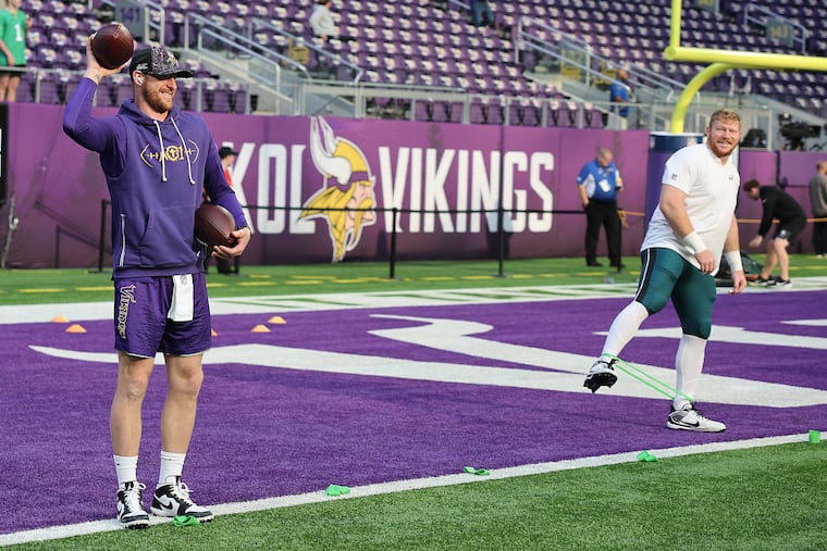 Eagles center Cam Jurgens (right) warms up next to Vikings quarterback Carson Wentz. Jurgens appeared to injure his right knee on the first play of the game.