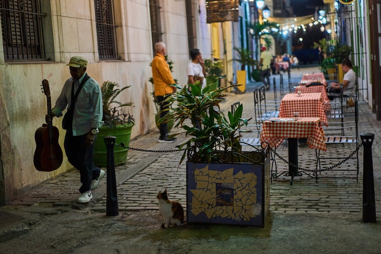 A street musician walks past a restaurant Wednesday in Havana.