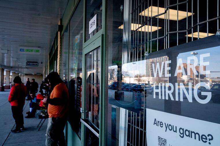 A "We Are Hiring" sign is displayed at a Game Stop in Baileys Crossroads, Va.