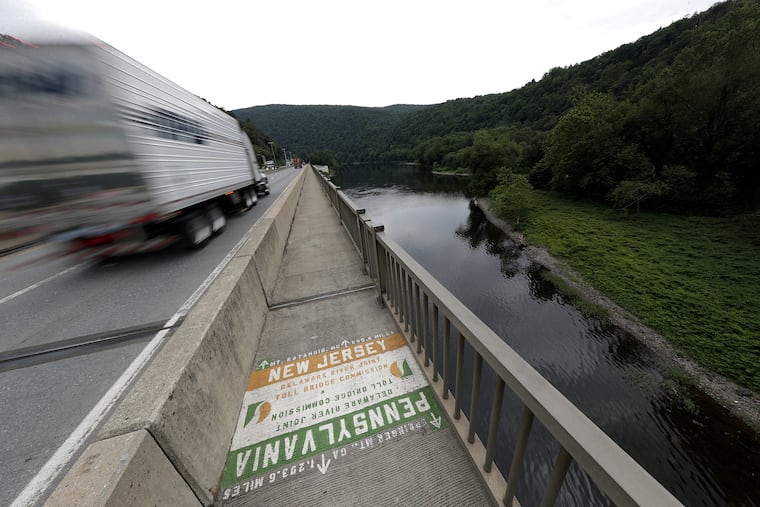 A truck motors past a marker on the Delaware Water Gap Toll Bridge in Monroe County. The Poconos Mountains region has been hard by the coronavirus.