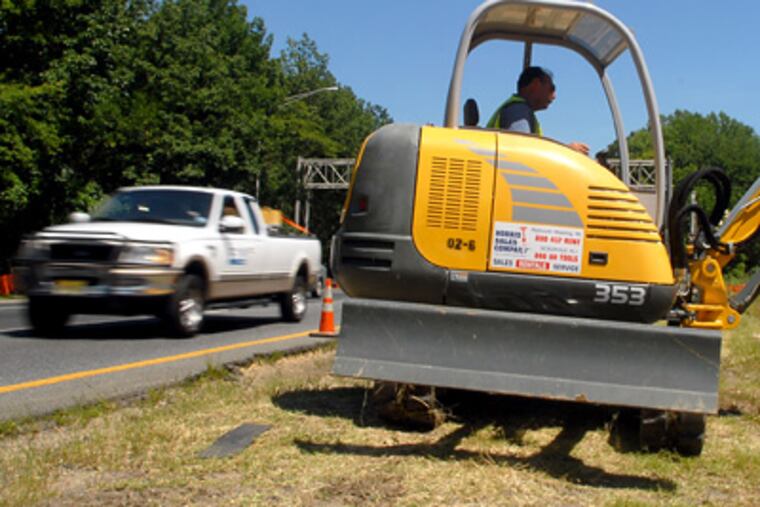 Construction worker George Vrabel works on the median between the southbound (left) and northbound lanes of an I-295 bridge. (Tom Gralish / Staff Photographer)