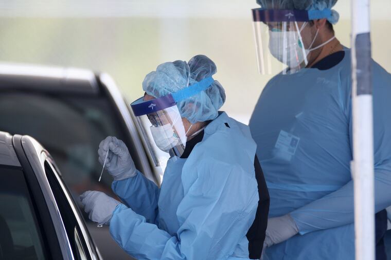 A medical worker administers a nasal swab to a patient at a new coronavirus testing site in Camden, N.J., on Wednesday, April 29, 2020.