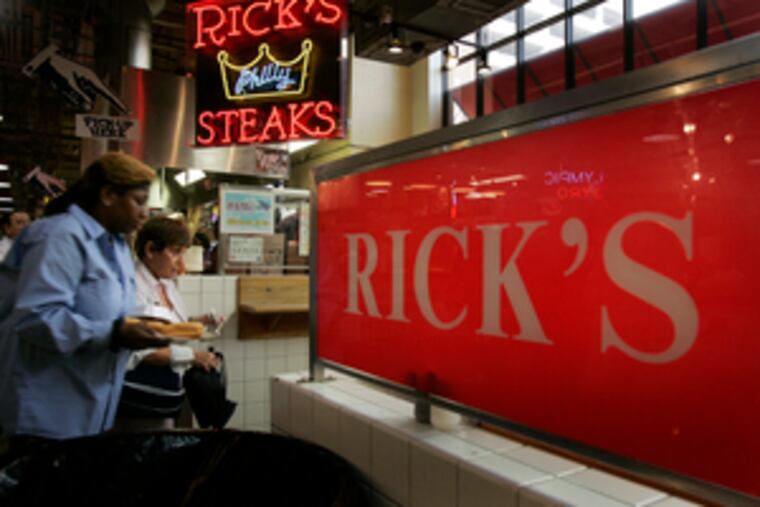 Lunch customers line up at Rick's Original Philly Steaks at the Reading Terminal Market. "We're still operating, and things are going very well," owner Rick Olivieri said.