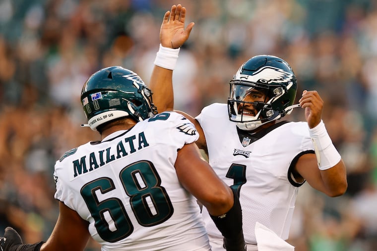 Eagles quarterback Jalen Hurts celebrates his first-quarter touchdown pass with offensive tackle Jordan Mailata against the New York Jets last Friday.