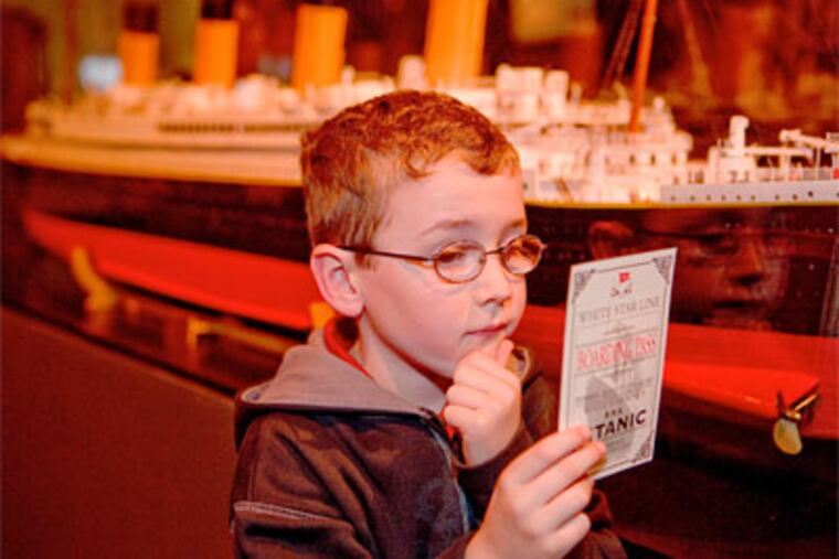 A young visitor examines his boarding pass. Visitors receive a boarding pass upon entry to the exhibit, inviting them to imagine that they are assuming the identity of an actual passenger. (Premier Exhibitions, Inc.)