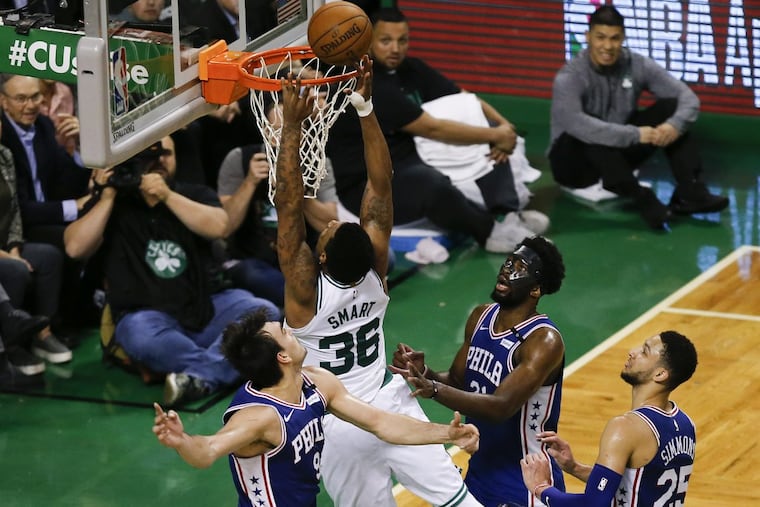 Celtics guard Marcus Smart puts back a miss for a basket past Sixers forward Dario Saric, center Joel Embiid and guard Ben Simmons late in the fourth-quarter in game five of the Eastern Conference semifinals on Wednesday, May 9, 2018 in Boston.