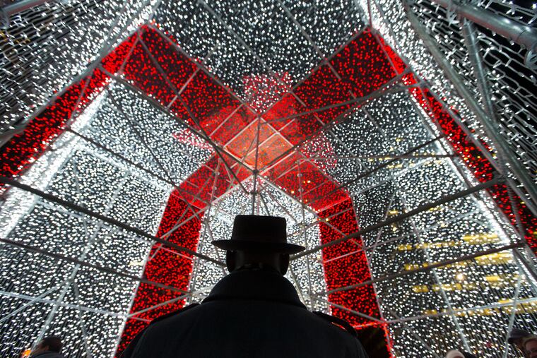 The Present at Love Park is sponsored by Bank of America to raise money for Philadelphia Parks, children’s books, and help for the homeless. Darryl Glover stands inside the three dimensional gift box made of strings of lights at Love Park on Dec. 7, 2018,