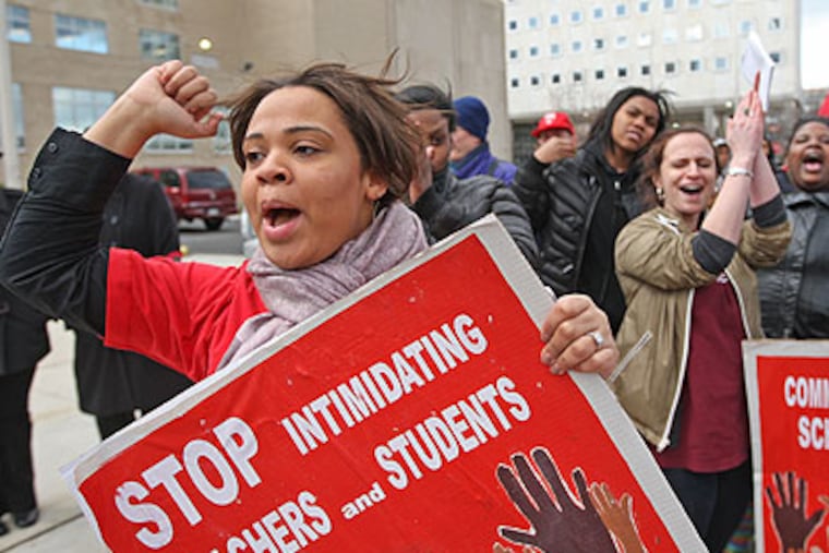 Shanee Garner, a teacher from Kensington High School, left, yields her support during a protest rally in front of the school district building Friday afternoon. (Michael Bryant / Staff Photographer)