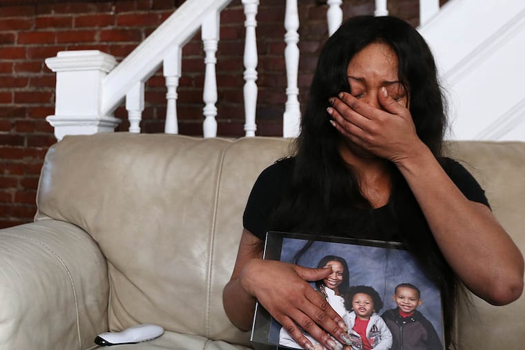 Dominique Lockwood holds a photo of her and her son Latif Wilson, who was killed in April. (DAVID MAIALETTI / STAFF PHOTOGRAPHER)