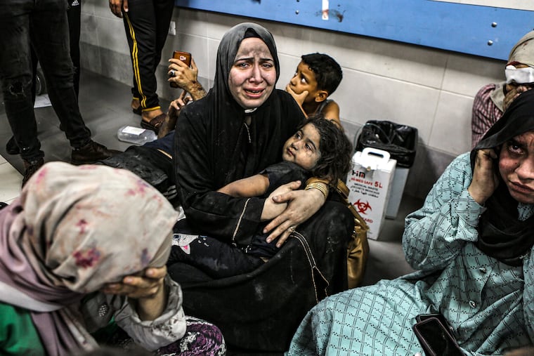 Wounded Palestinians sit in al-Shifa hospital in Gaza City, central Gaza Strip, after arriving from al-Ahli hospital following an explosion there, Tuesday, Oct. 17, 2023.