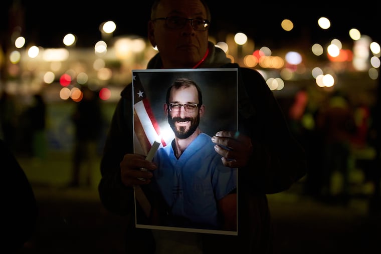A mourner holds a photo during a Wednesday vigil in Minneapolis for Alex Pretti, who was shot and killed Saturday by federal immigration enforcement agents.