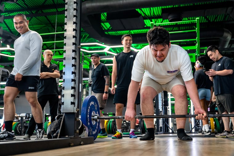 Sushi chefs work out at Fusion Gyms in South Philadelphia. They get together regularly, trading both exercise tips and fish intel. Deadlifting is Carlos Wills. Behind him, from left are Joseph Nguyen, Alex Jiang, Kevin Yanaga, Albert Zheng, and Dan Santana.