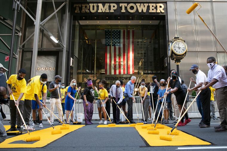 New York Mayor Bill de Blasio, wearing orange mask, participates in painting Black Lives Matter on Fifth Avenue in front of Trump Tower.