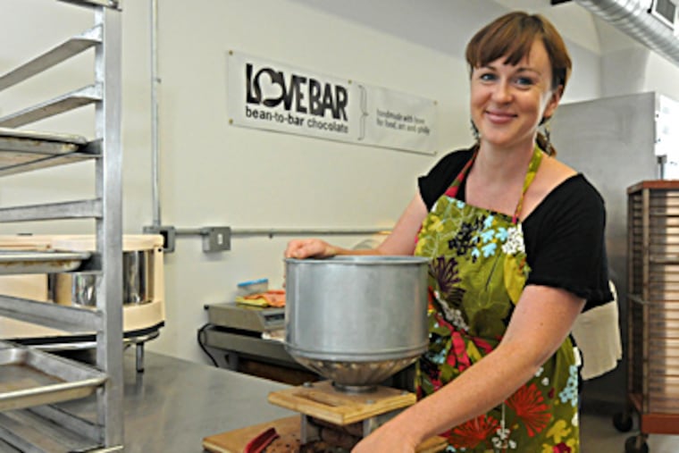 Tegan Hagy grinds cacao beans to make PhillyLoveBars in her space at the old Globe Dye Works building in Frankford. APRIL SAUL / Staff Photographer