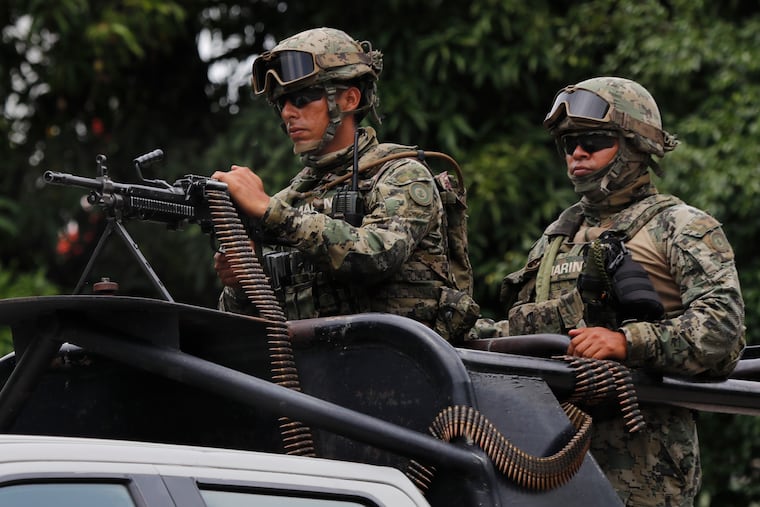 Mexican marines ride in the back of a pick up truck as they escort the caravan carrying Mexico's Minister of Defense, in Tapachula, Mexico, Tuesday, June 11, 2019. Mexican officials say they are beginning deployment of 6,000 National Guard troops for immigration enforcement, an accelerated commitment made as part of an agreement with the United States last week to head off threatened U.S. tariffs on imports from Mexico. (AP Photo/Marco Ugarte