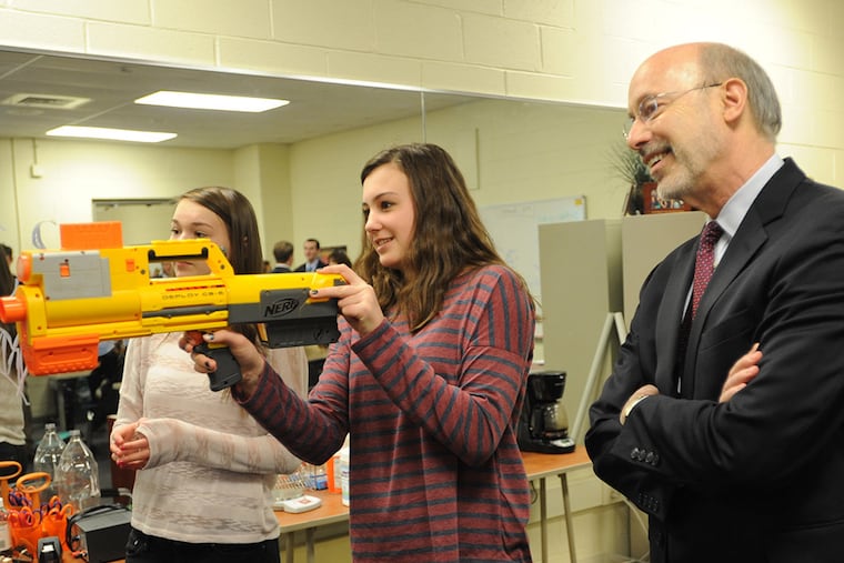 Gov. Tom Wolf, right, watches as Downingtown STEM Academy students, Julie Grier, left and Audrey Liebharolt, center, conduct a physics experiment during a tour of the facility Wednesday, March 4, 2015 in Downingtown, Pa. (Philadelphia Inquirer/Bradley C Bower)