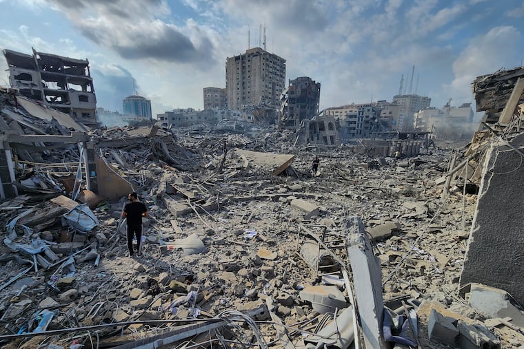 Palestinians walk through the rubble of buildings destroyed by Israeli airstrikes in Gaza City on Tuesday. Gazan civilians who object to Hamas’ authoritarian rule have no avenue to challenge it, and are now at the mercy of Hamas’ war and Israel’s bombs, writes Trudy Rubin.