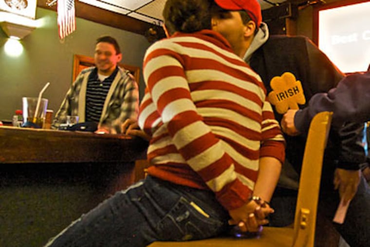A man kisses his hand-cuffed girlfriend, a bartender at the New Princeton tavern, after a raid by state police. (John Costello / Staff Photographer )