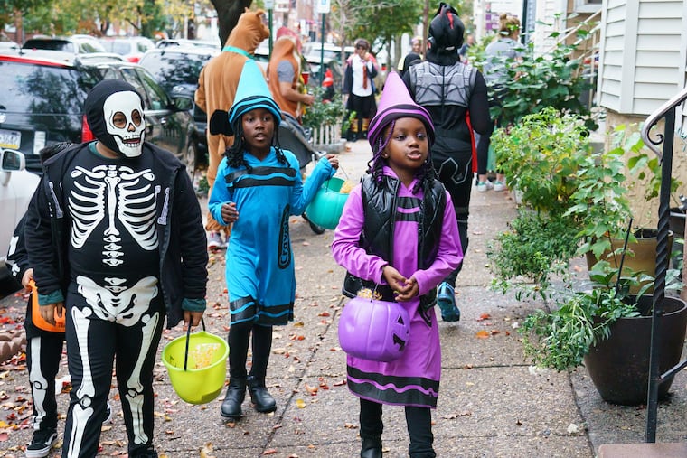 Zendaya Payne, back center, and her cousin Mahogany Johnson, front right, trick or treat on South 13th Street, between Morris and Reed Streets, in 2019.