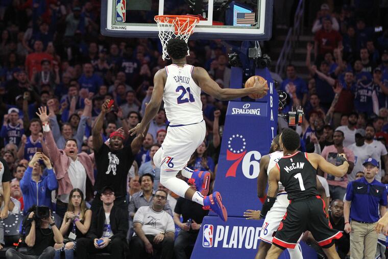 Joel Embiid of the Sixers does a windmill dunk against the Raptors during the 4th quarter of their NBA playoff game at the Wells Fargo Center on May 2, 2019.